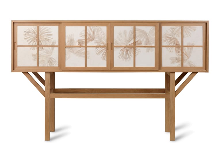 Wooden cabinet with glass-fronted doors displaying botanical leaf specimens against white backing.