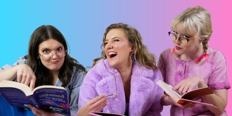 Three women in pink and purple clothing laugh while reading scripts against a blue and pink gradient backdrop.