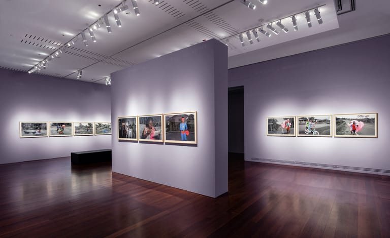 Gallery interior with framed photographs displayed on white walls under gallery lighting.