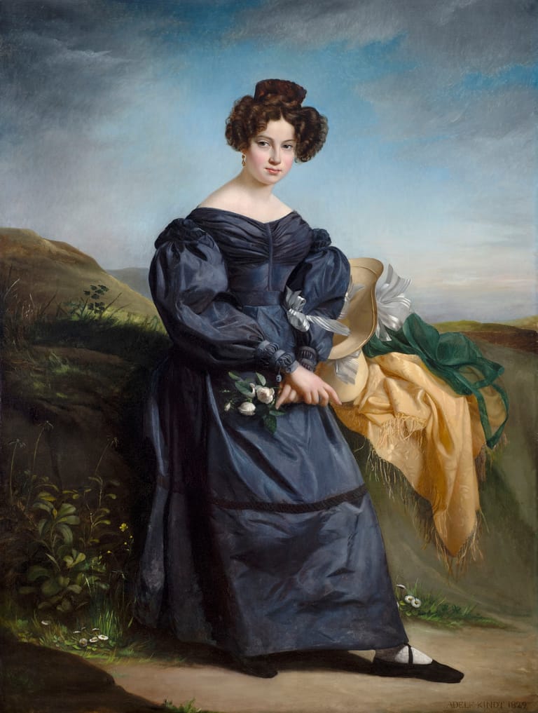 Woman in a navy silk dress with puffed sleeves stands holding fabric against a rolling landscape backdrop.