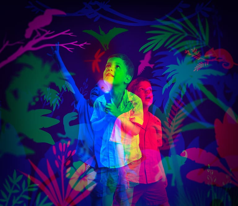 Performer bathed in vibrant multicoloured stage lighting amid tropical foliage projections.