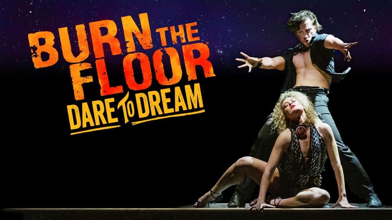 Two performers in dramatic pose on stage with "Burn the Floor: Dare to Dream" title text in yellow and orange.