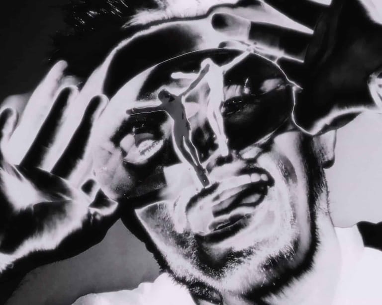 High-contrast black and white portrait of a person wearing headphones, eyes closed in concentration or enjoyment.