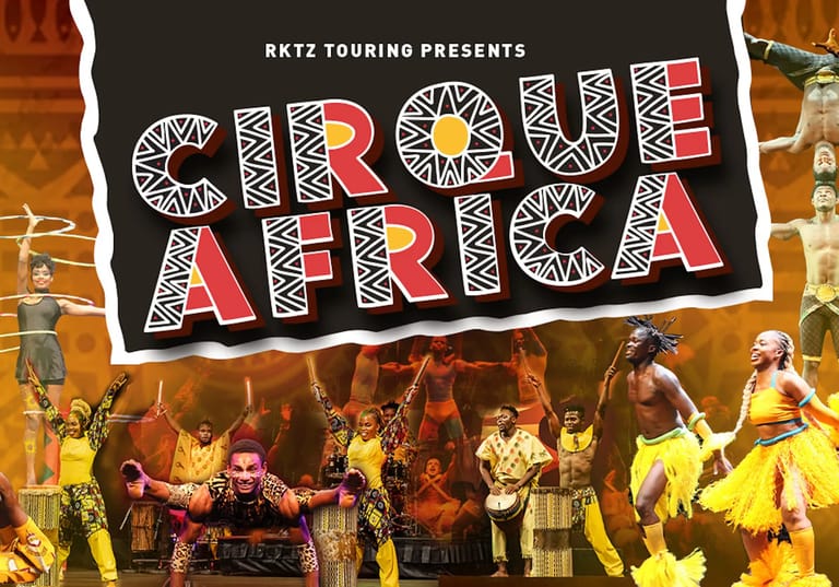 Cirque Africa performers in vibrant yellow costumes dance and leap across a stage lit with warm golden lighting.