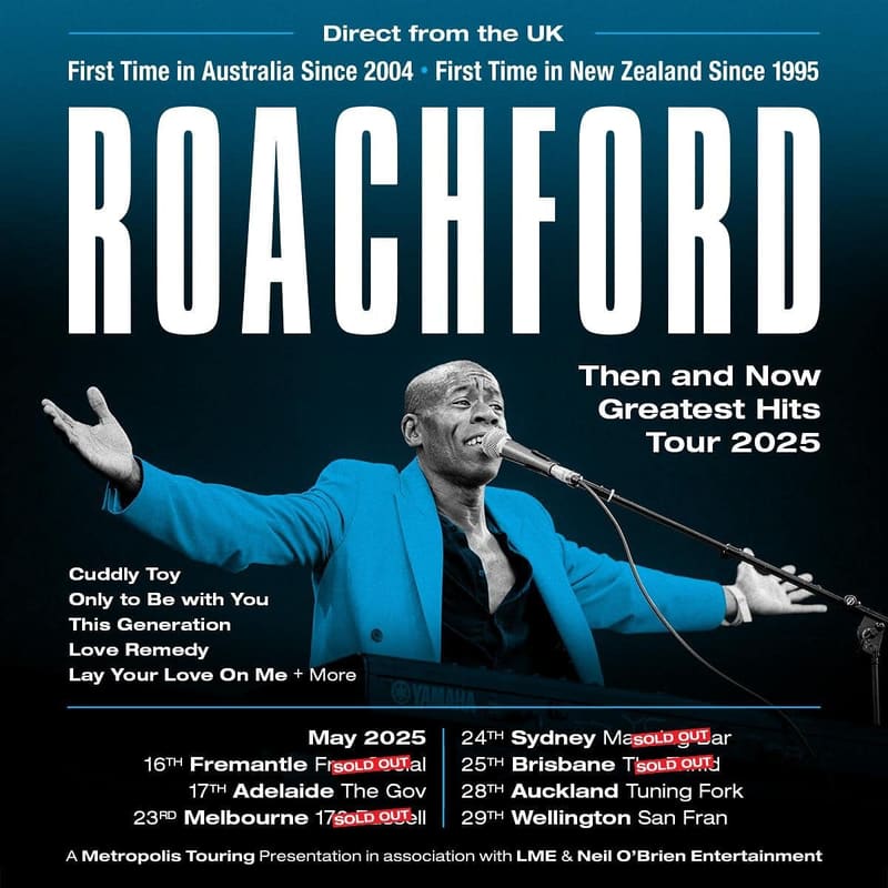 Roachford in a bright blue jacket performs at a microphone during his "Then and Now Greatest Hits Tour 2025" Australian dates.