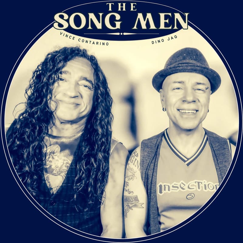 Two male performers in sepia tones within a circular frame against a dark blue background; one with long curly hair, one wearing a fedora.