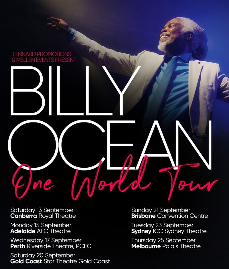 Performer in light blue suit with arm extended against blue-lit stage backdrop during concert tour promotion.