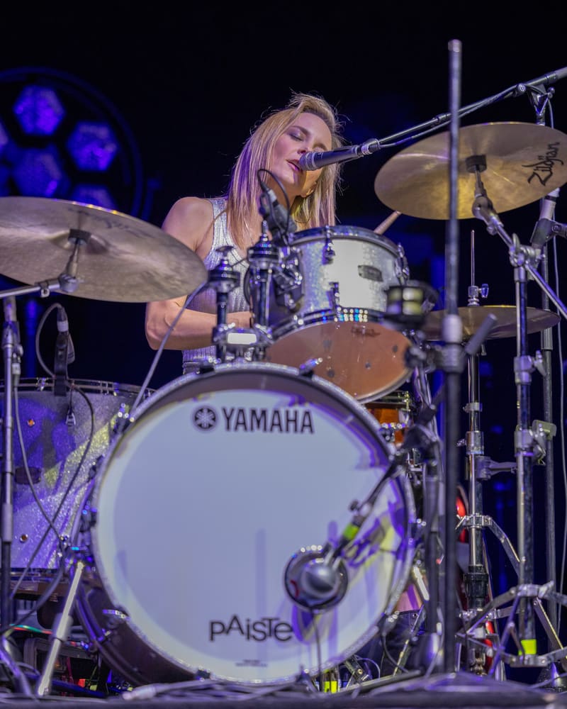 Drummer performs at Yamaha kit under blue stage lighting during The Corrs 2023 Australian tour.