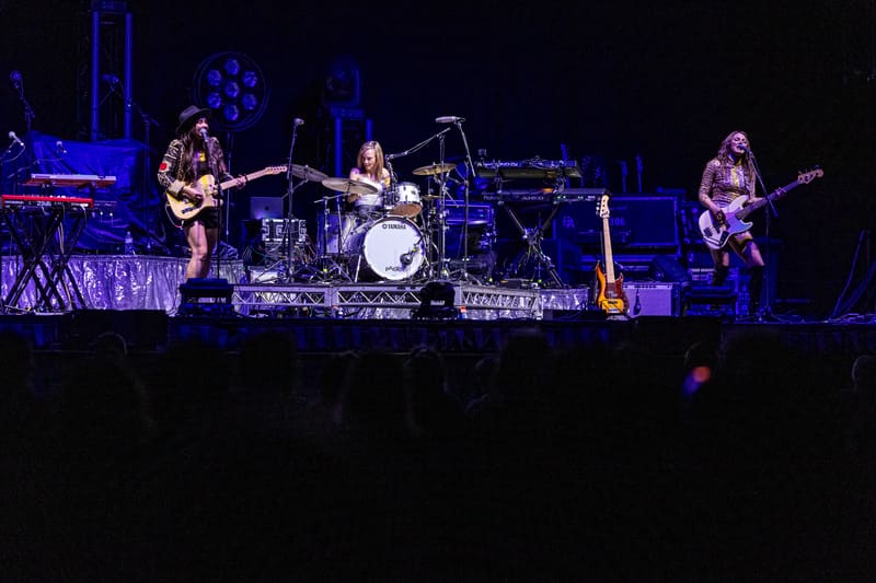 Four musicians performing on stage bathed in blue lighting during The Corrs 2023 Australian Tour.