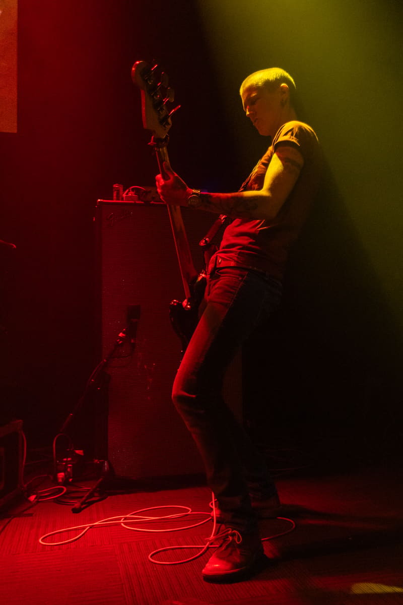 Guitarist performs on stage illuminated by red and amber spotlights during Jebediah's Gum Up The Bearings 2023 Tour.