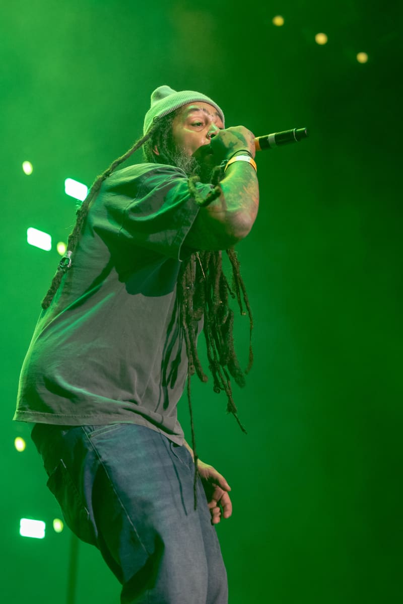 Performer singing into microphone under green stage lighting at Fridayz Live concert.