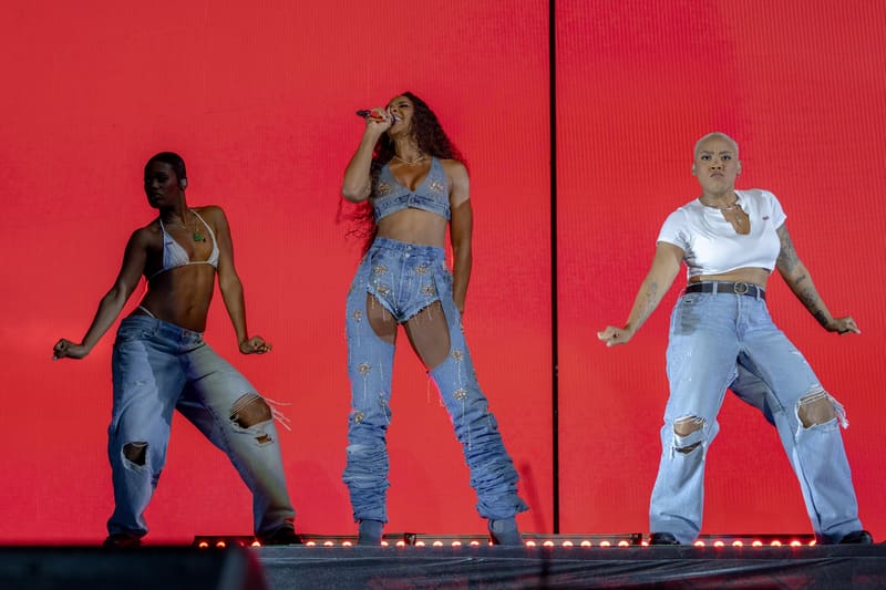 Three performers dance on stage against a vibrant red backdrop during Fridayz Live.