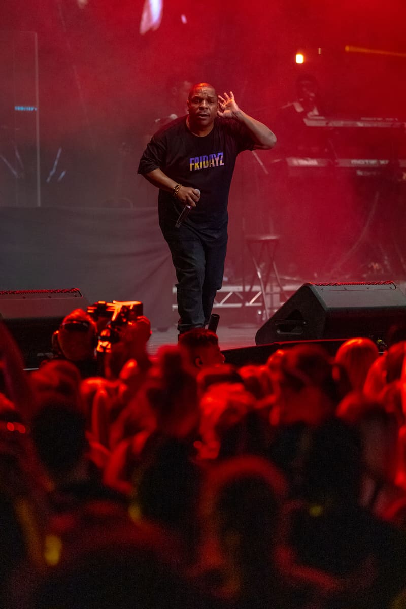 Performer gestures expressively to a crowd bathed in red stage lighting during Illtown Sluggaz – Fridayz Live.