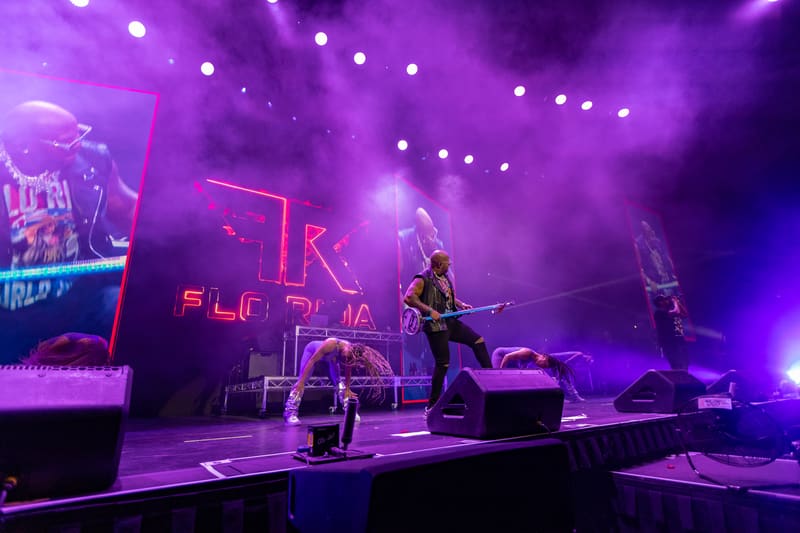Musicians performing on stage under vibrant purple and pink lighting at Fridayz Live.