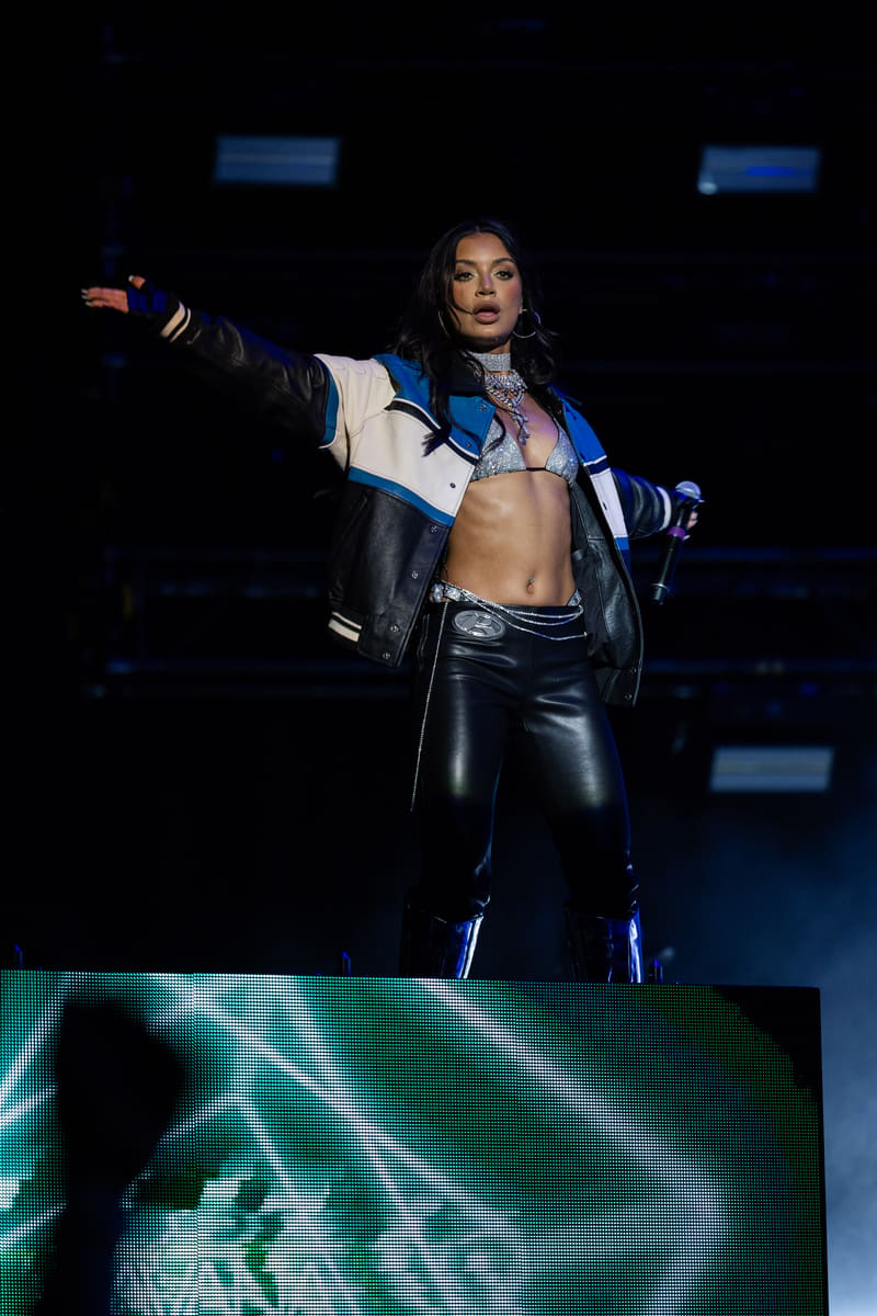 Performer in black and blue leather outfit striking a dynamic pose on stage during Fridayz Live.