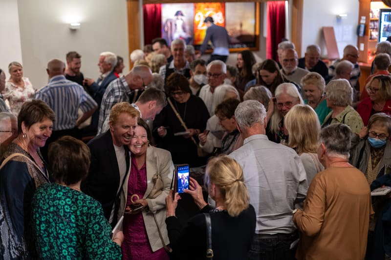 Diverse crowd of gallery visitors mingling and viewing artwork at the Tommy Fleming exhibition opening.