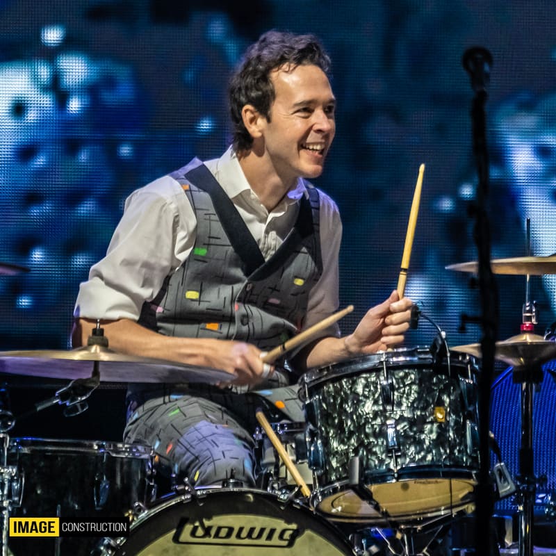 Drummer performing at the kit during Split Enz: Forever Enz 2026 Tour, lit by blue stage lighting.