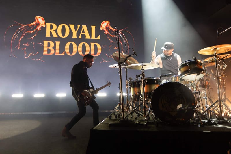 Guitarist and drummer perform on stage beneath the "Royal Blood" logo during a live concert.